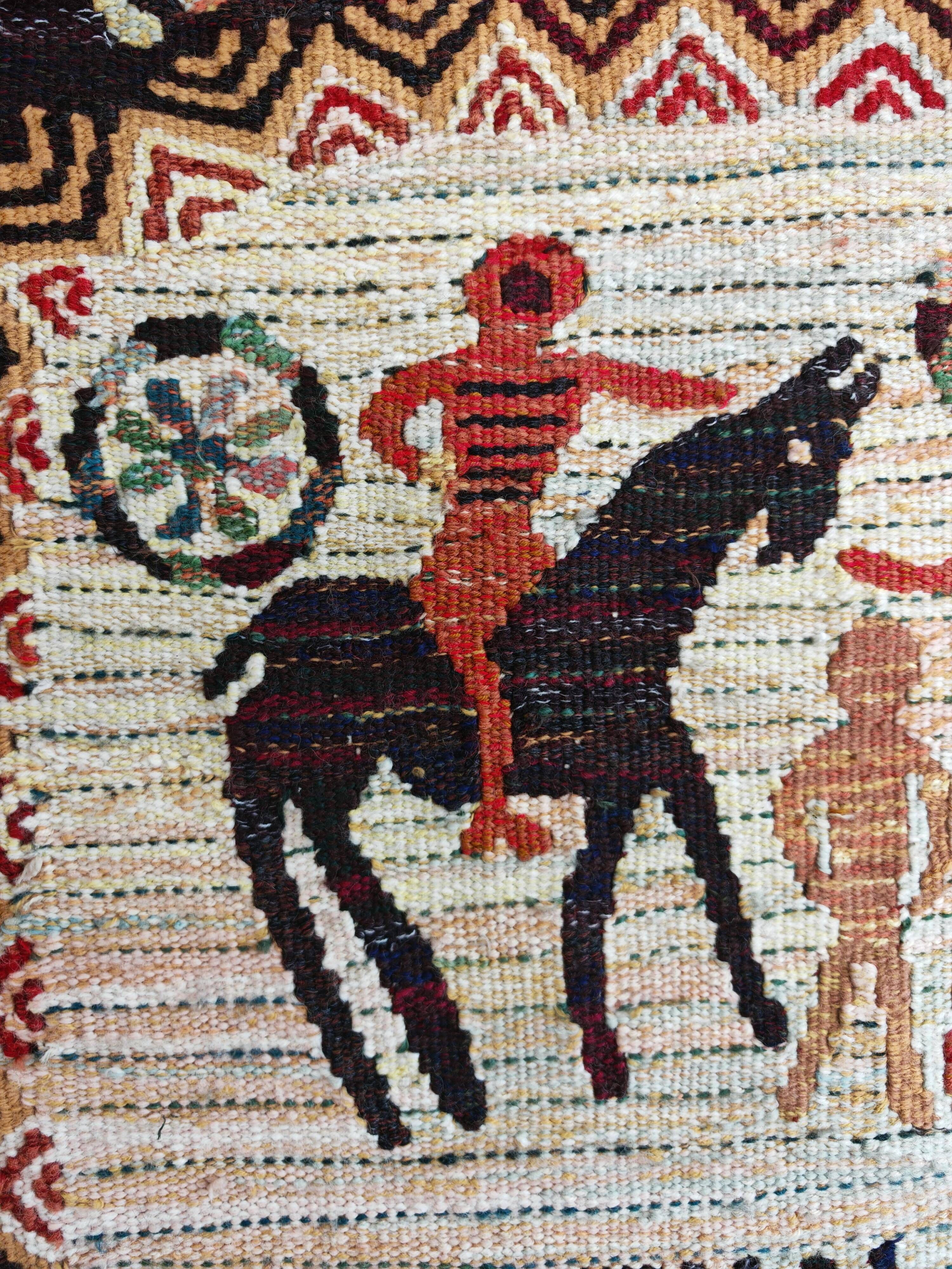 Vintage handwoven tapestry with a folk scene and archaic Slavic writing.