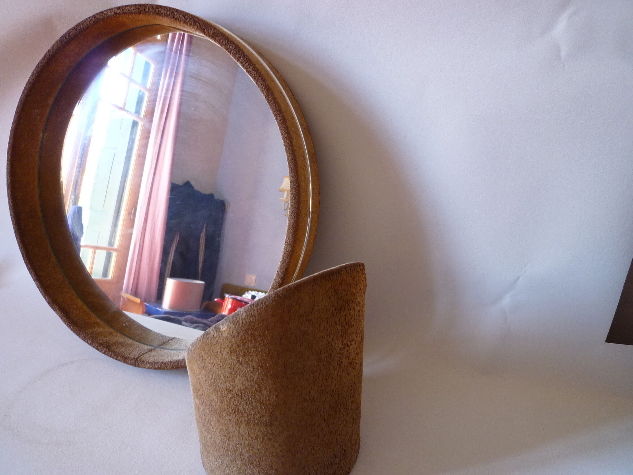 Round mirror on inclined cylindrical support