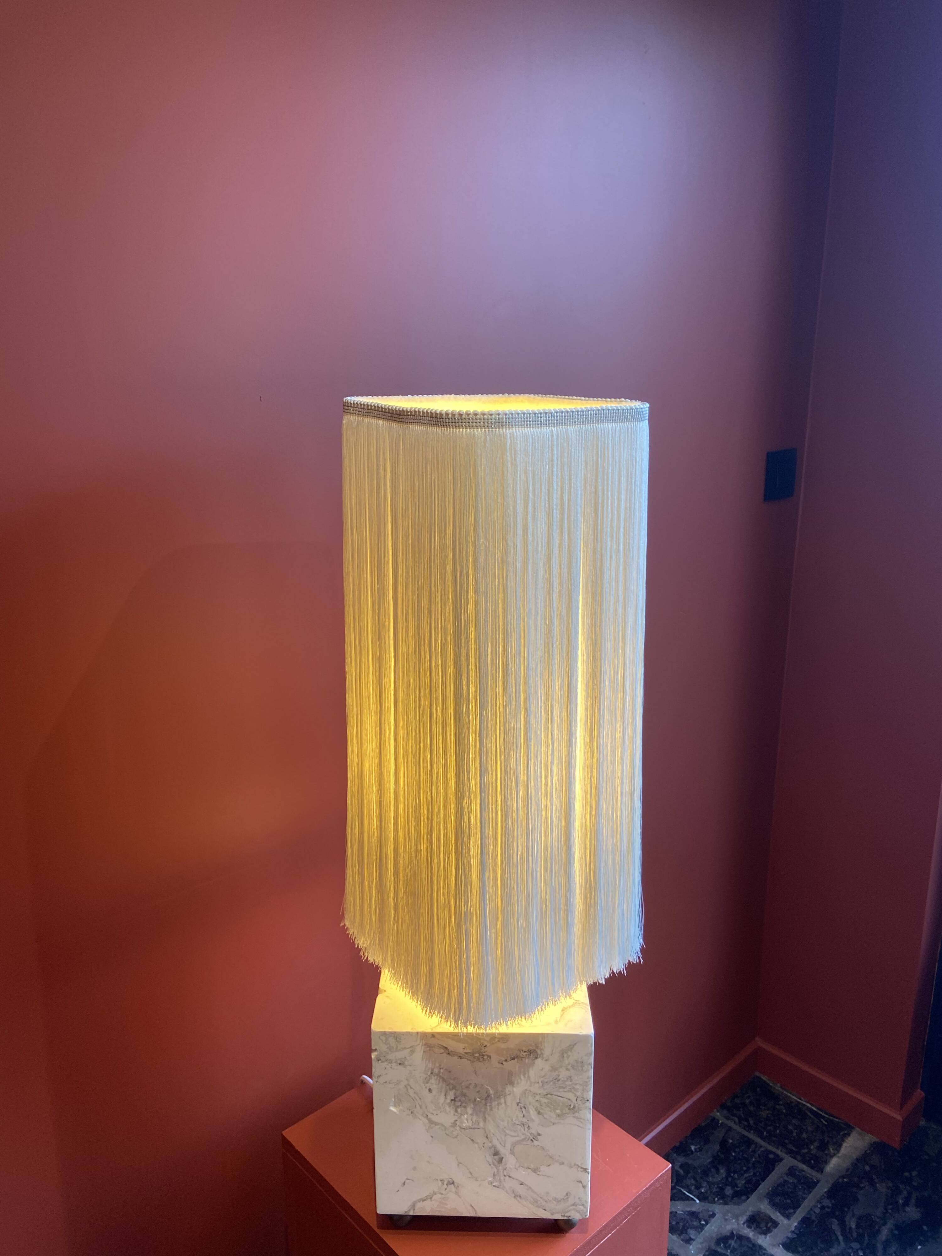 Beige marble stucco base, Houles white ecru fringed lampshade.