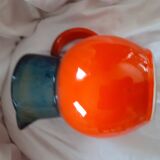 Pitcher in glazed sandstone. orange background and fade colors at the neckline.