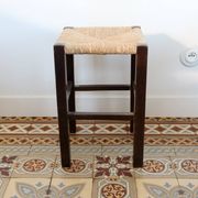Vintage rustic stool in wood with a straw seat.