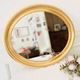 Oval wall mirror in gilded wood