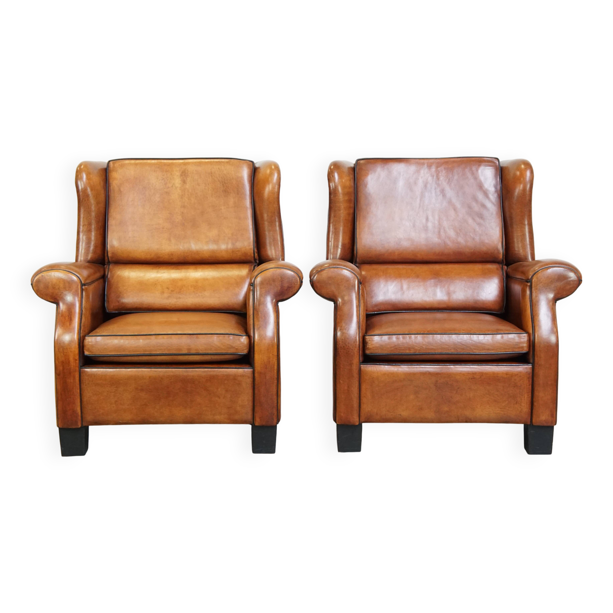 Set of 2 very comfortable large sheepskin armchairs elegantly finished with black piping