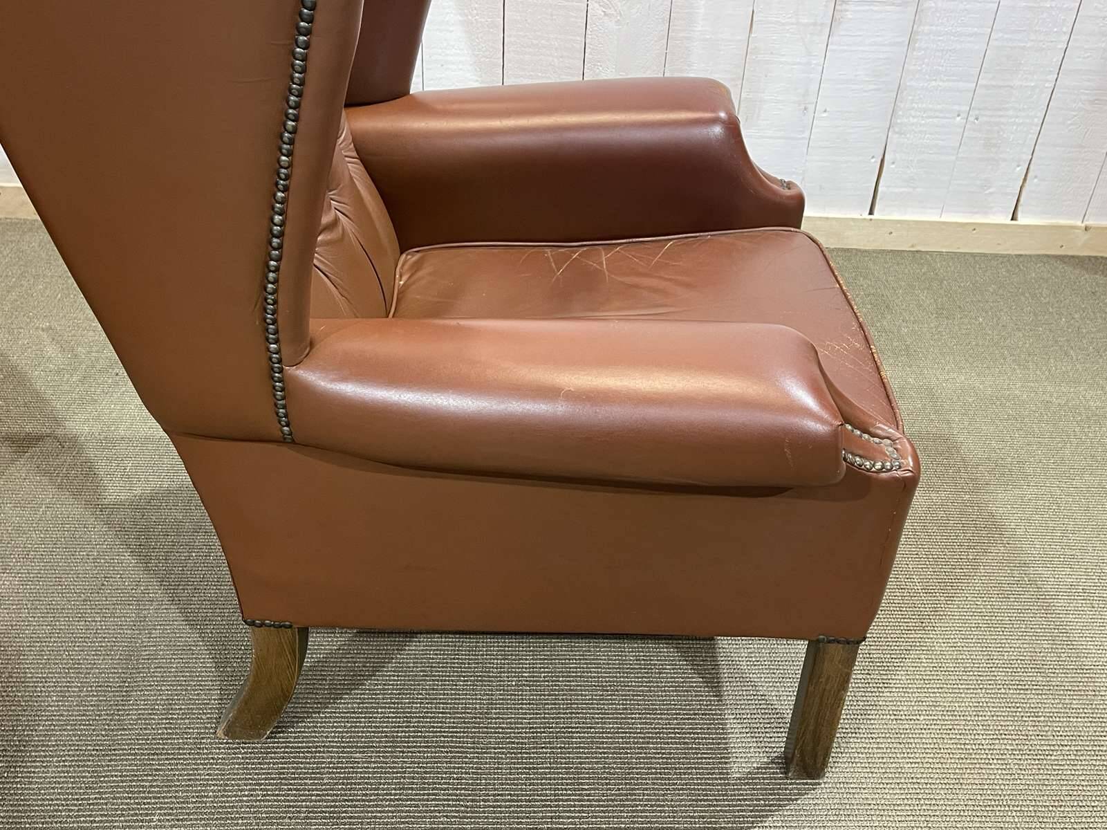 Pair of brown leather wingback Chesterfield armchairs from the 1970s.
