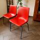 Pair of red plastic chairs with metal frame