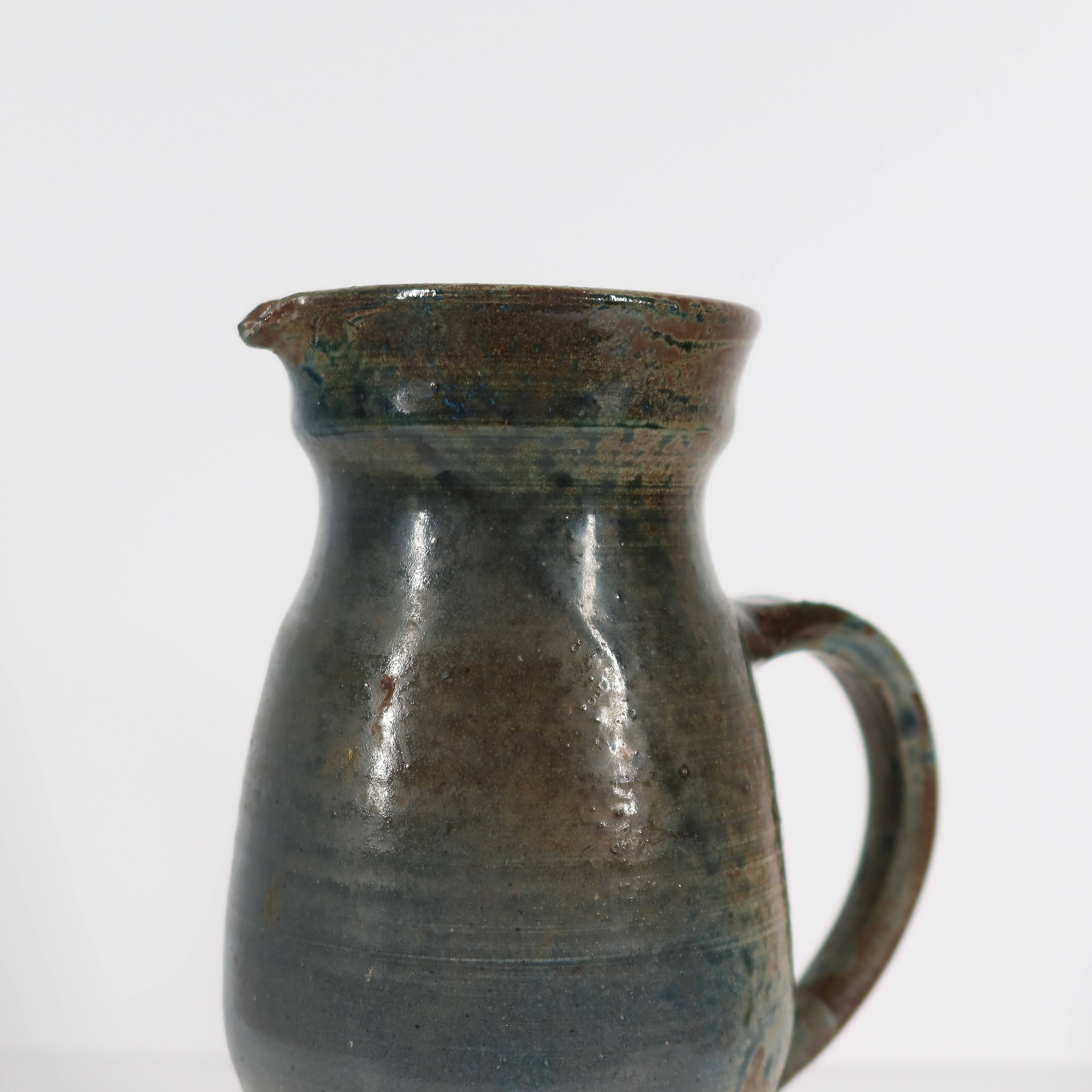 Handcrafted stoneware pitcher with blue-green hues, signed piece
