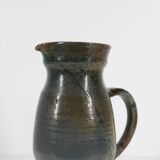 Handcrafted stoneware pitcher with blue-green hues, signed piece