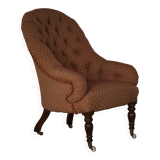 Victorian mahogany armchair, with wheels and coloured fabric, England, early 1900s.