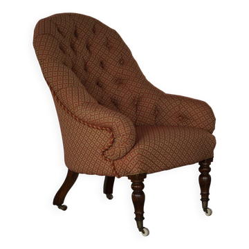 Victorian mahogany armchair, with wheels and coloured fabric, England, early 1900s.