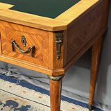 Louis XVI style marquetry desk. The top is decorated with green leather.