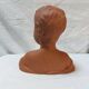 Terracotta bust of a smiling little boy.