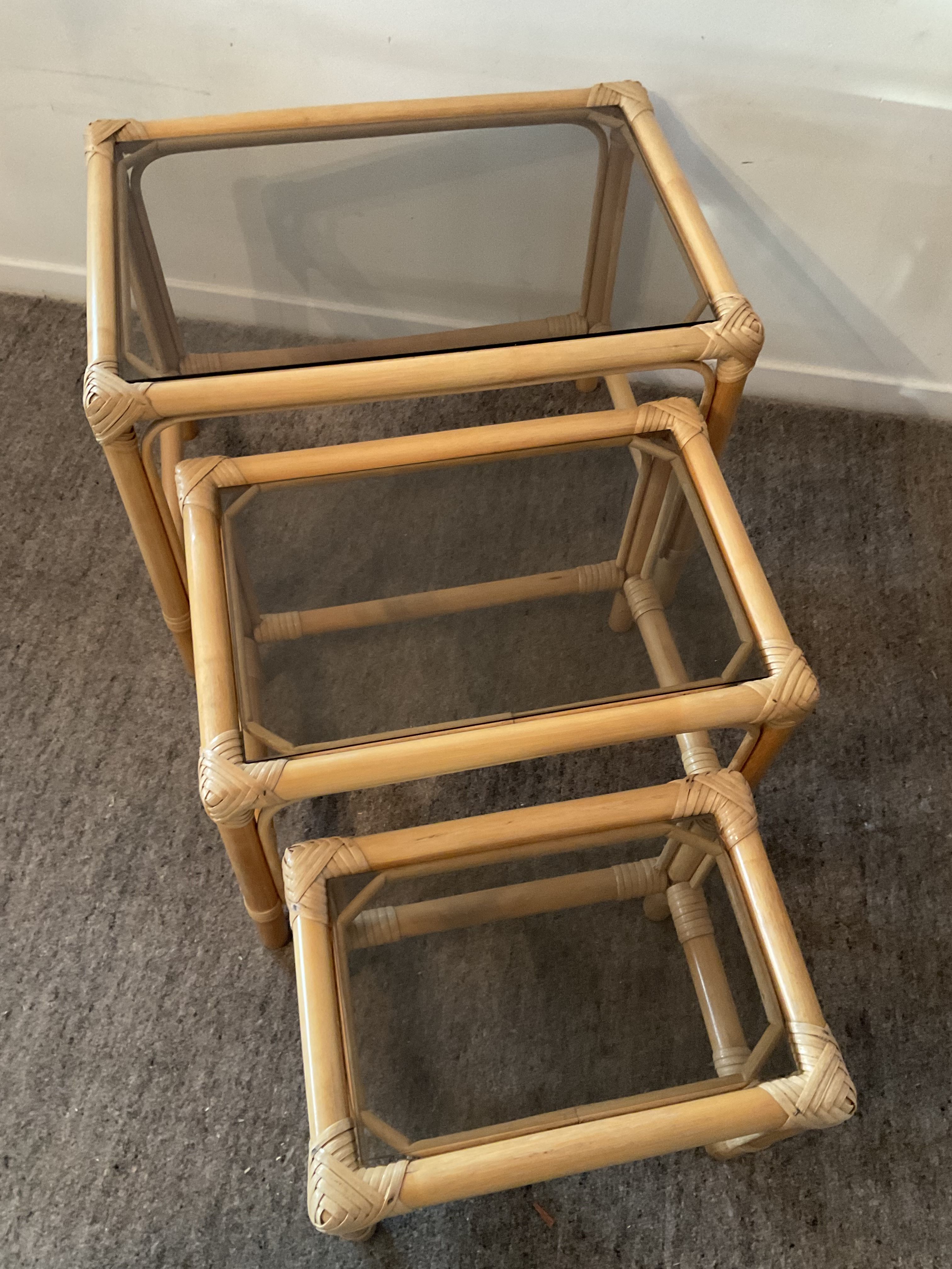Trio of vintage pull-out tables in rattan and smoked glass 70s