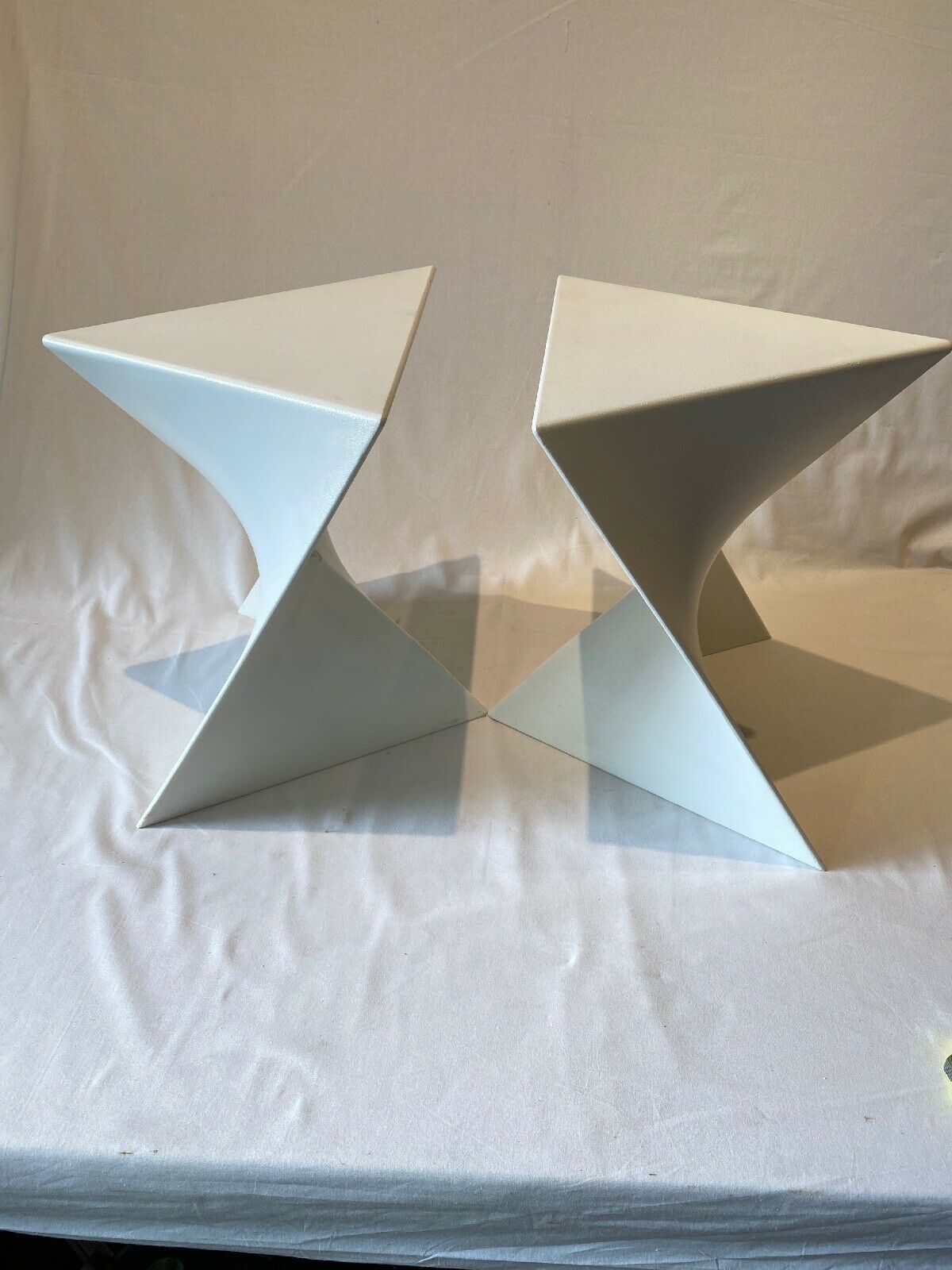 Pair of unmarked triangular white design stools