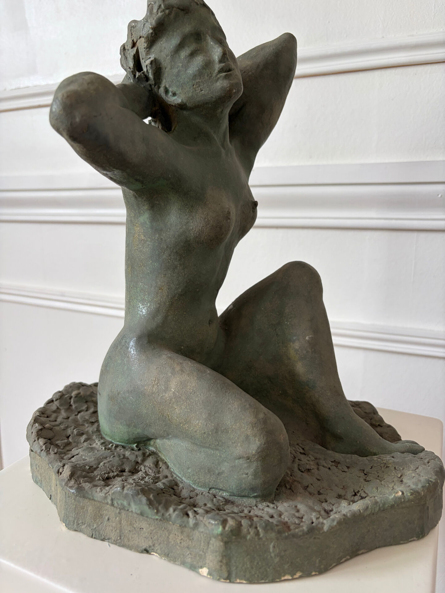 Sculpture of a naked woman titled "Youth" in terracotta.