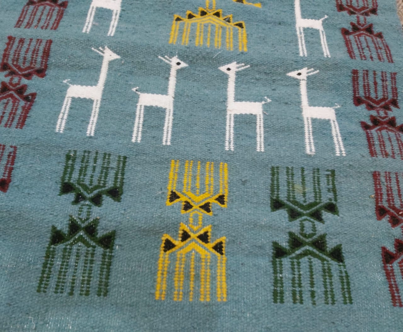 Blue carpet with gazelle patterns woven by hand