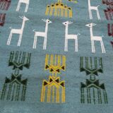 Blue carpet with gazelle patterns woven by hand