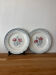 Ensemble de deux assiettes plates fleuries en faïence