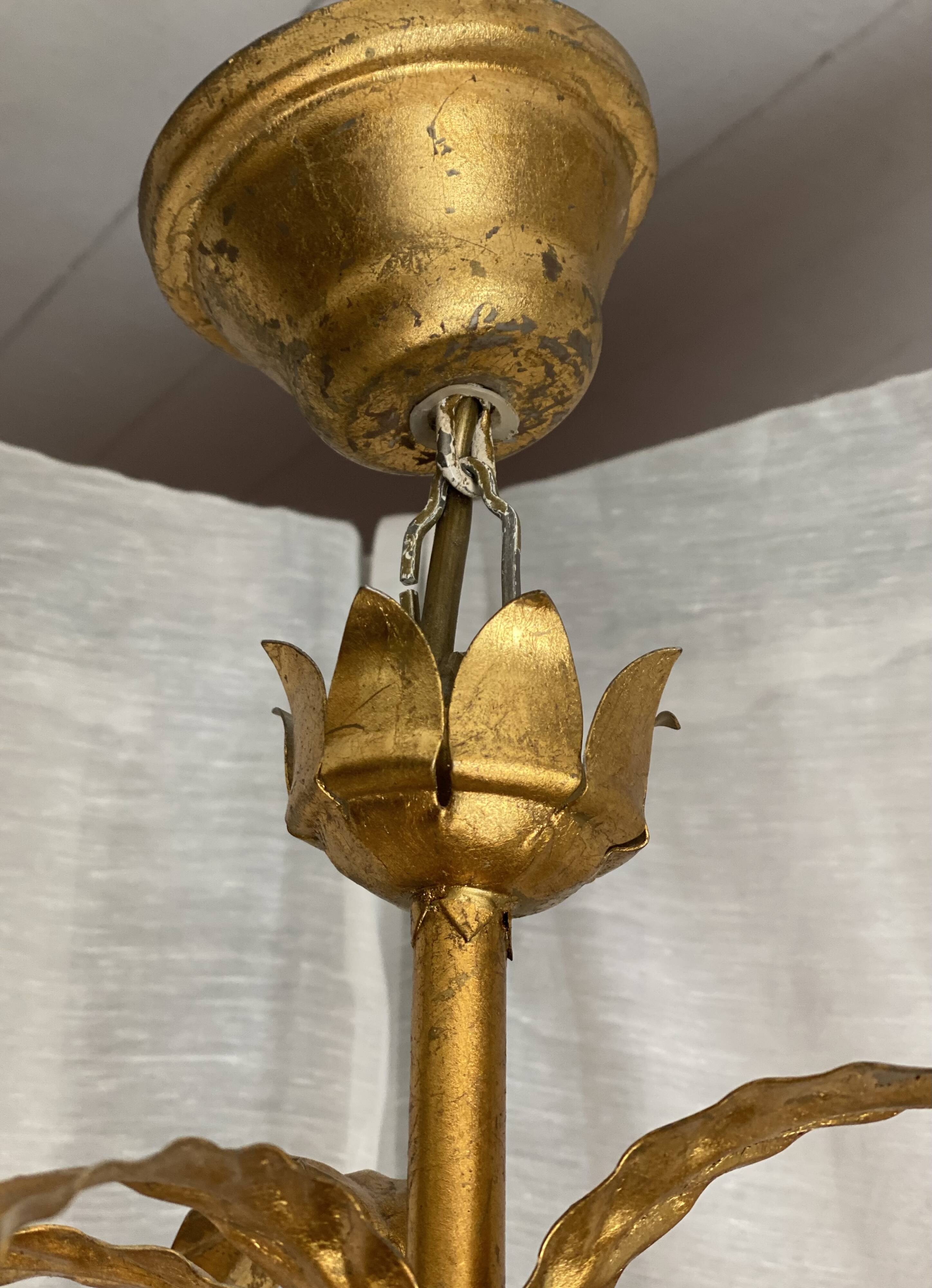 Vintage 1970s golden metal palm chandelier in the style of JANSEN.