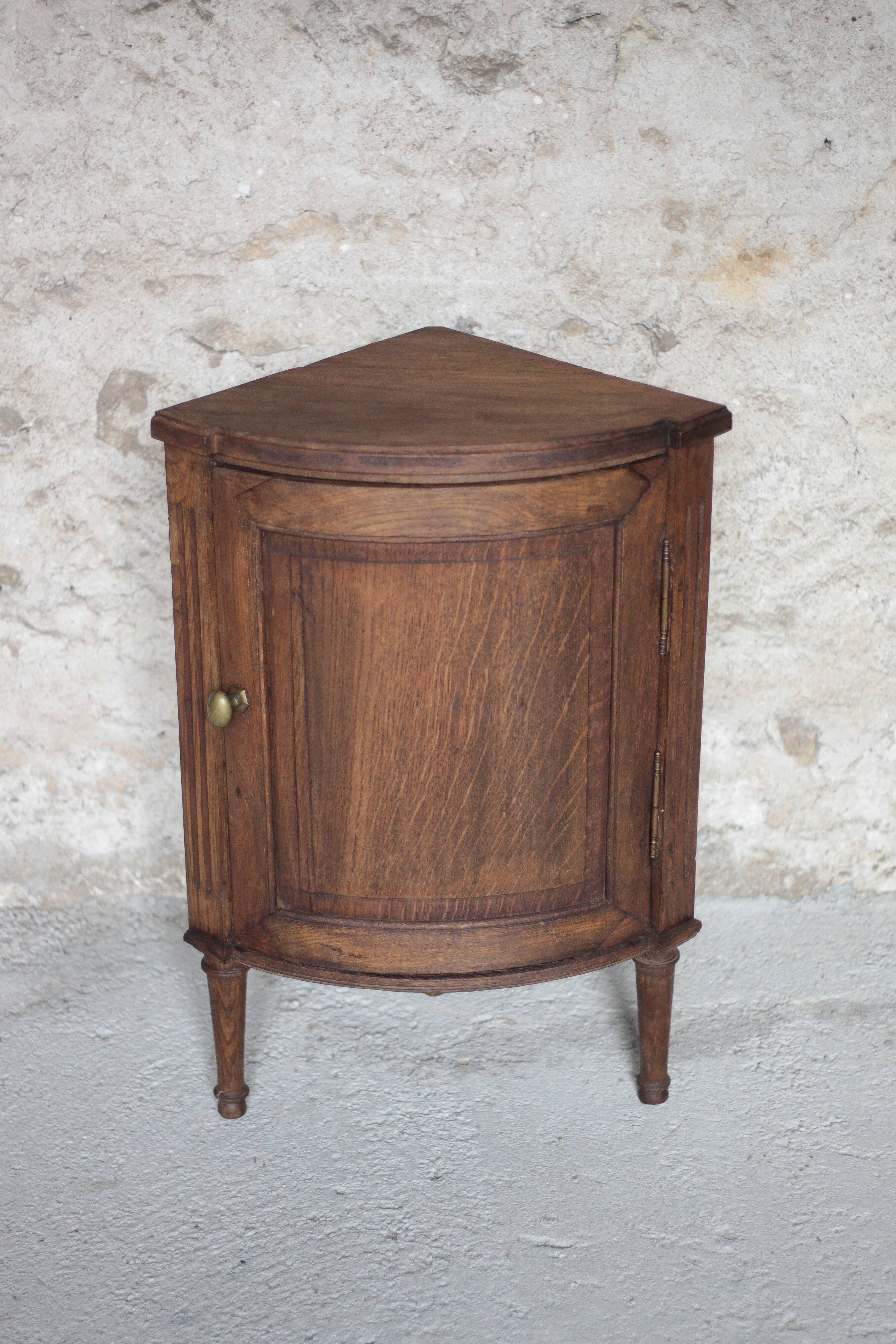 Antique wooden corner cabinet with a curved door.