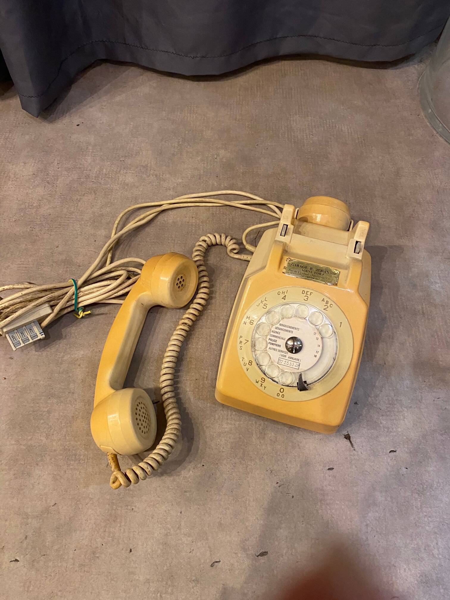 Old dial telephone from the 80s temat quimper bakelite yellow and beige