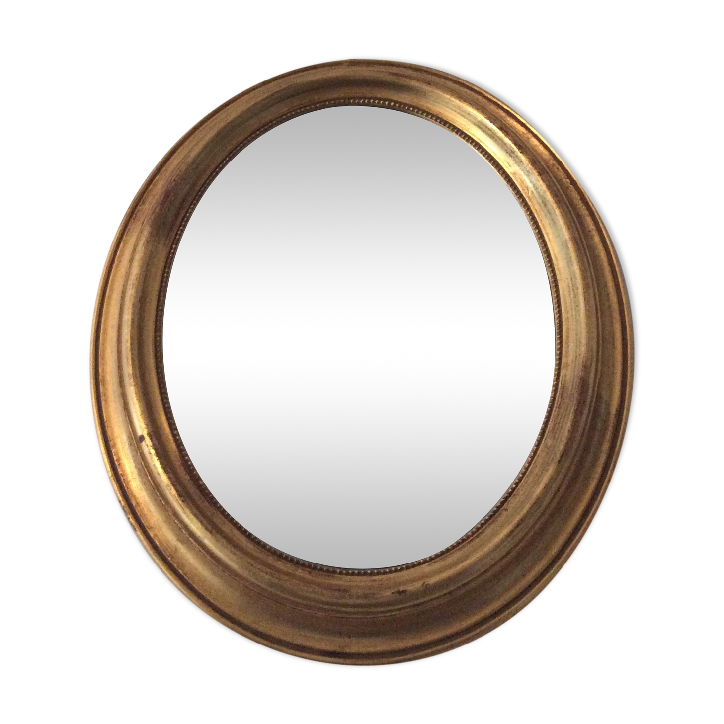 Old oval mirror in gilded wood