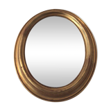 Old oval mirror in gilded wood