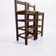 Set of 2 vintage wooden bar stools with woven straw seats.