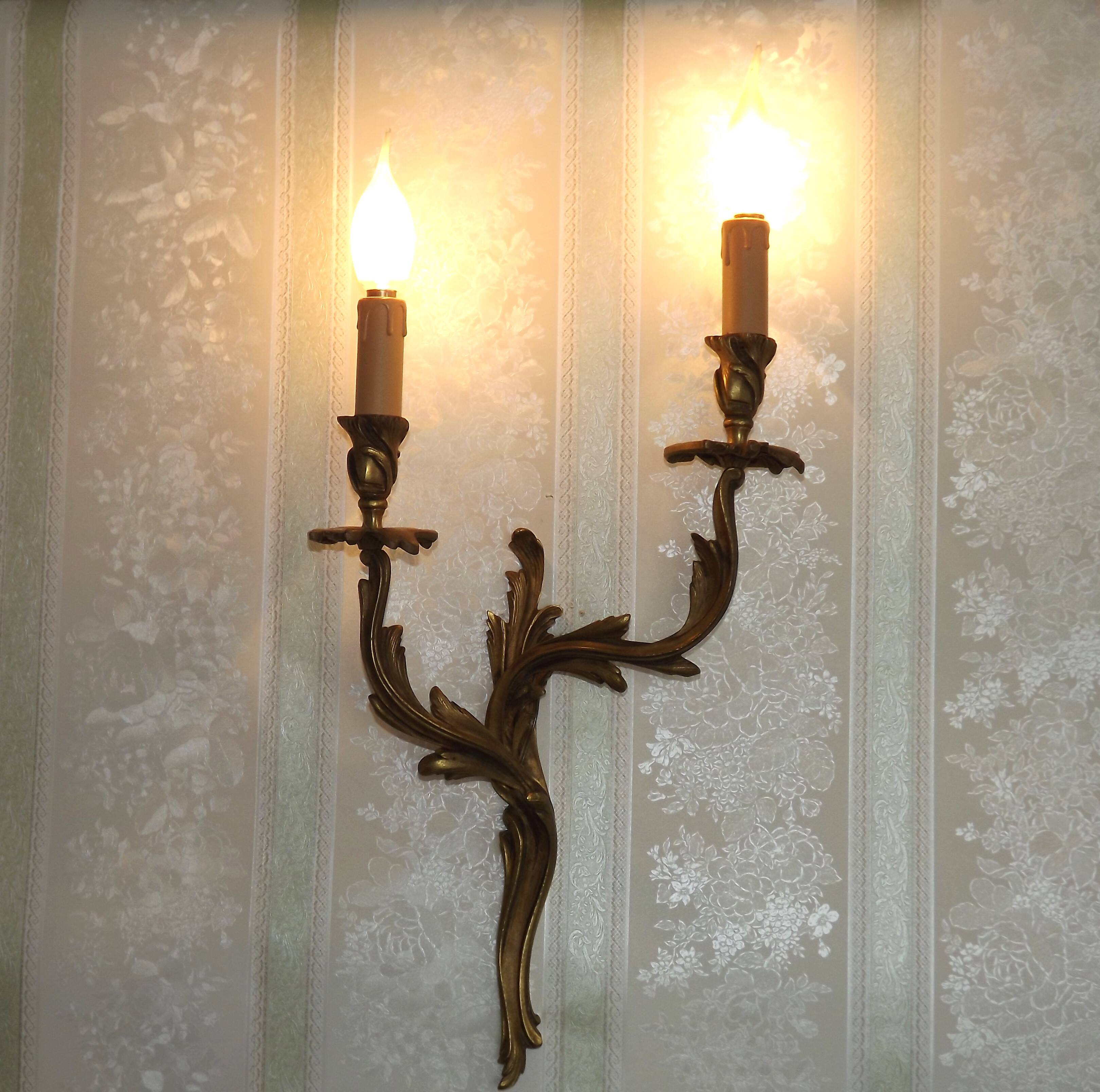 Apply two bronze wall lights decorated with acanthus leaves.