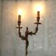 Apply two bronze wall lights decorated with acanthus leaves.