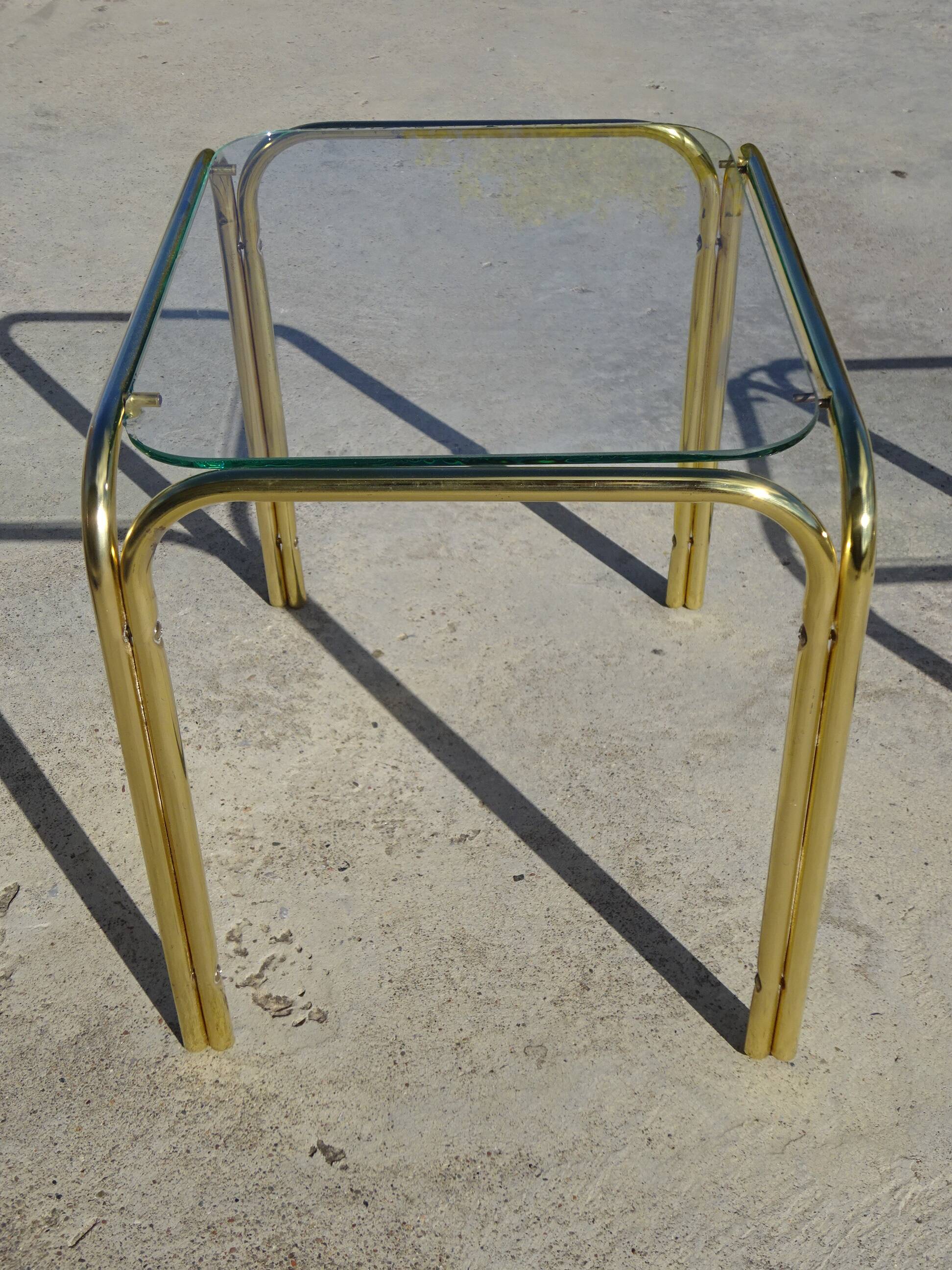 Nested tubular tables in gold metal.