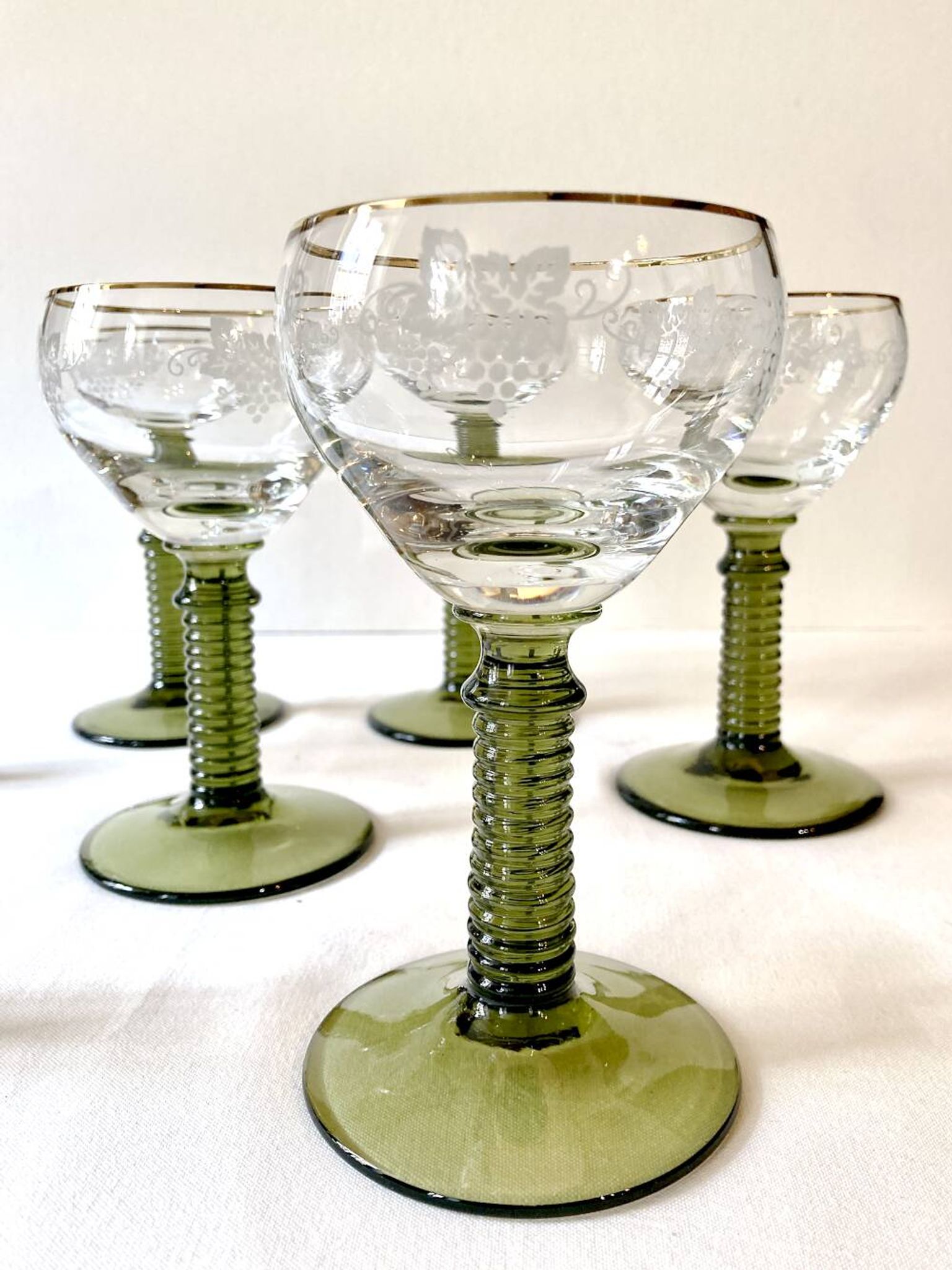 7 Alsace Roemer wine glasses, moss green stepped bases and gold trim.