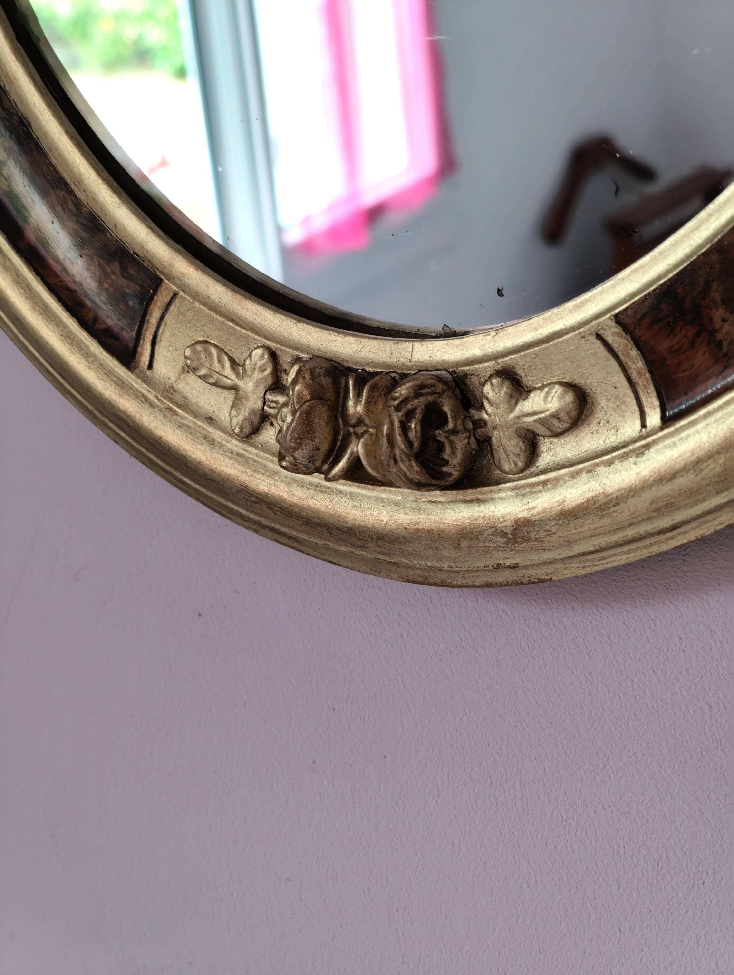 Antique medallion mirror with a gilded and relief-carved frame.