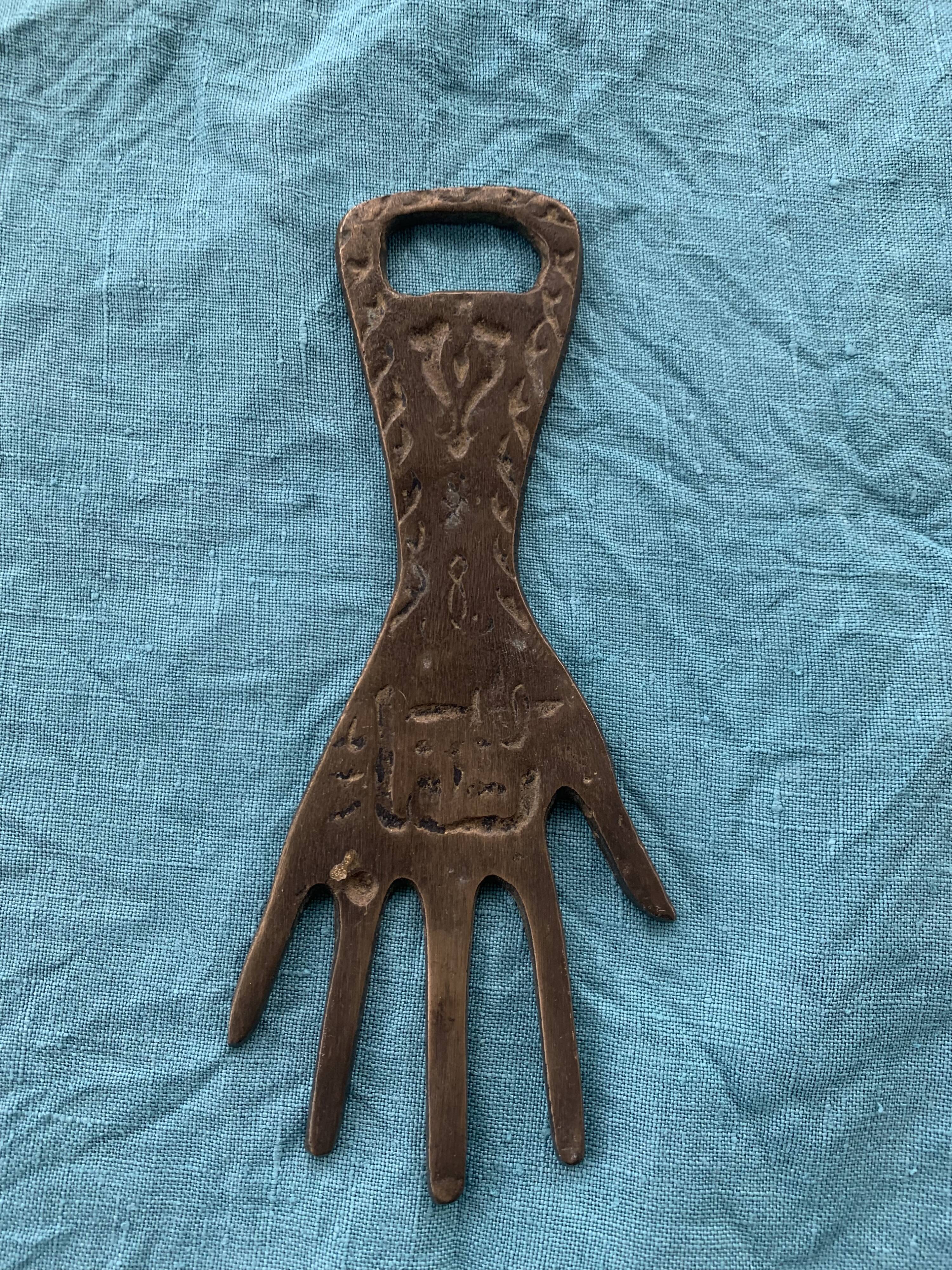 Two brass bottle openers in the shape of a chiseled hand vintage oriental décor