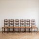 Set of 6 rustic wooden chairs with woven straw.