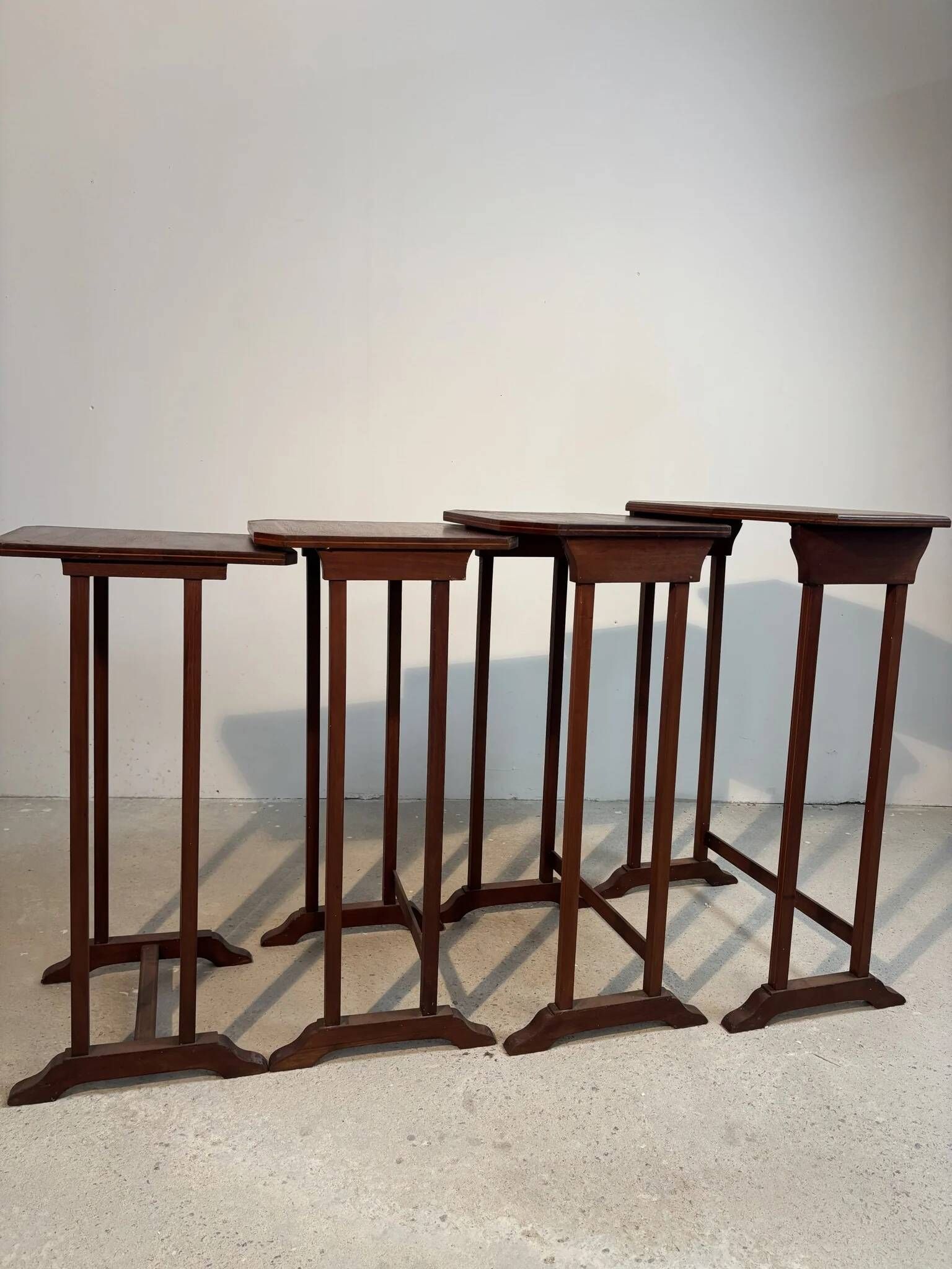 Four nesting tables with polygonal tops and decorative inlays.