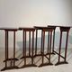 Four nesting tables with polygonal tops and decorative inlays.