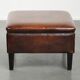 Large dark brown square ottoman made of sheepskin with black piping