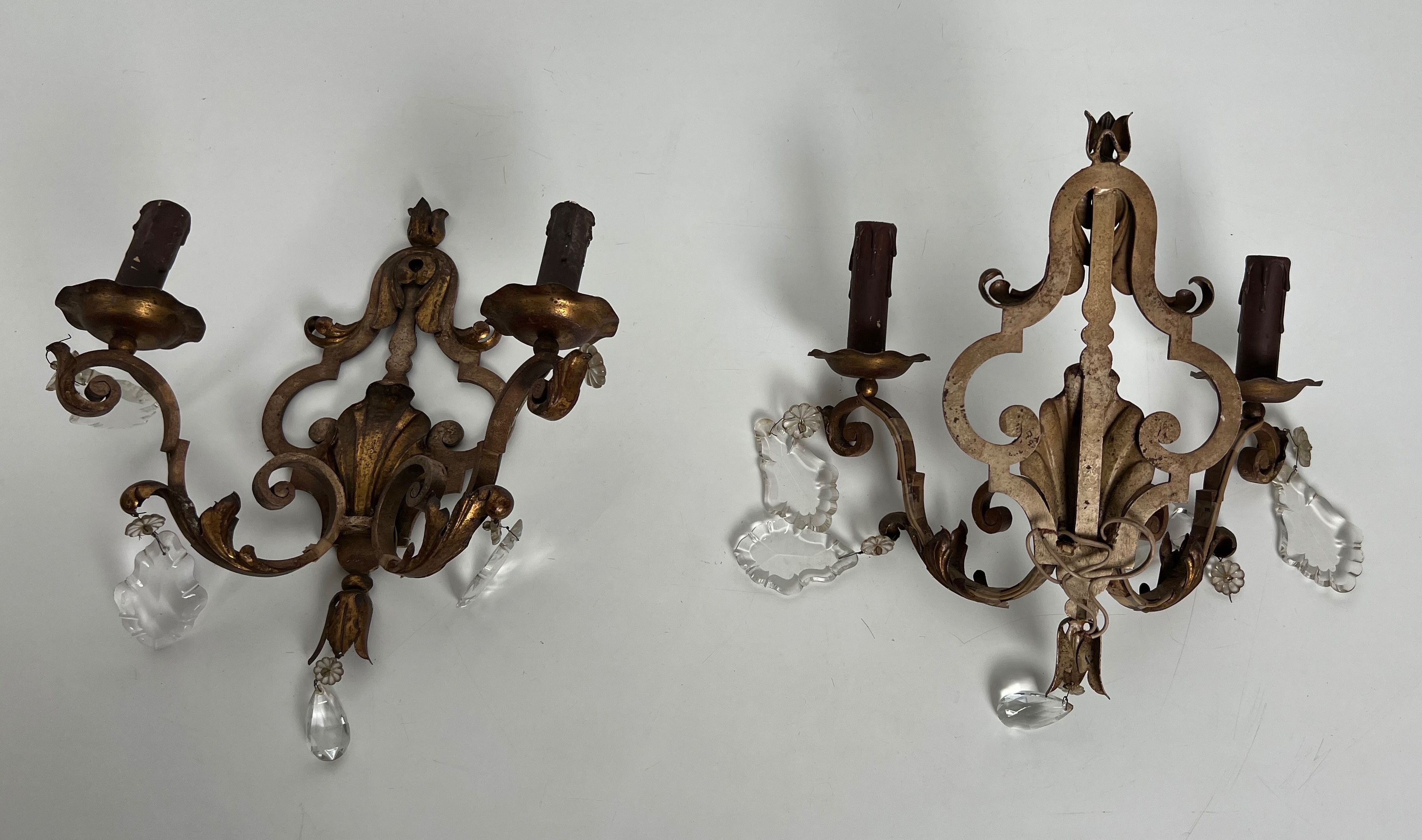 Pair of patinated wrought iron wall sconces with golden acanthus leaves and crystals.