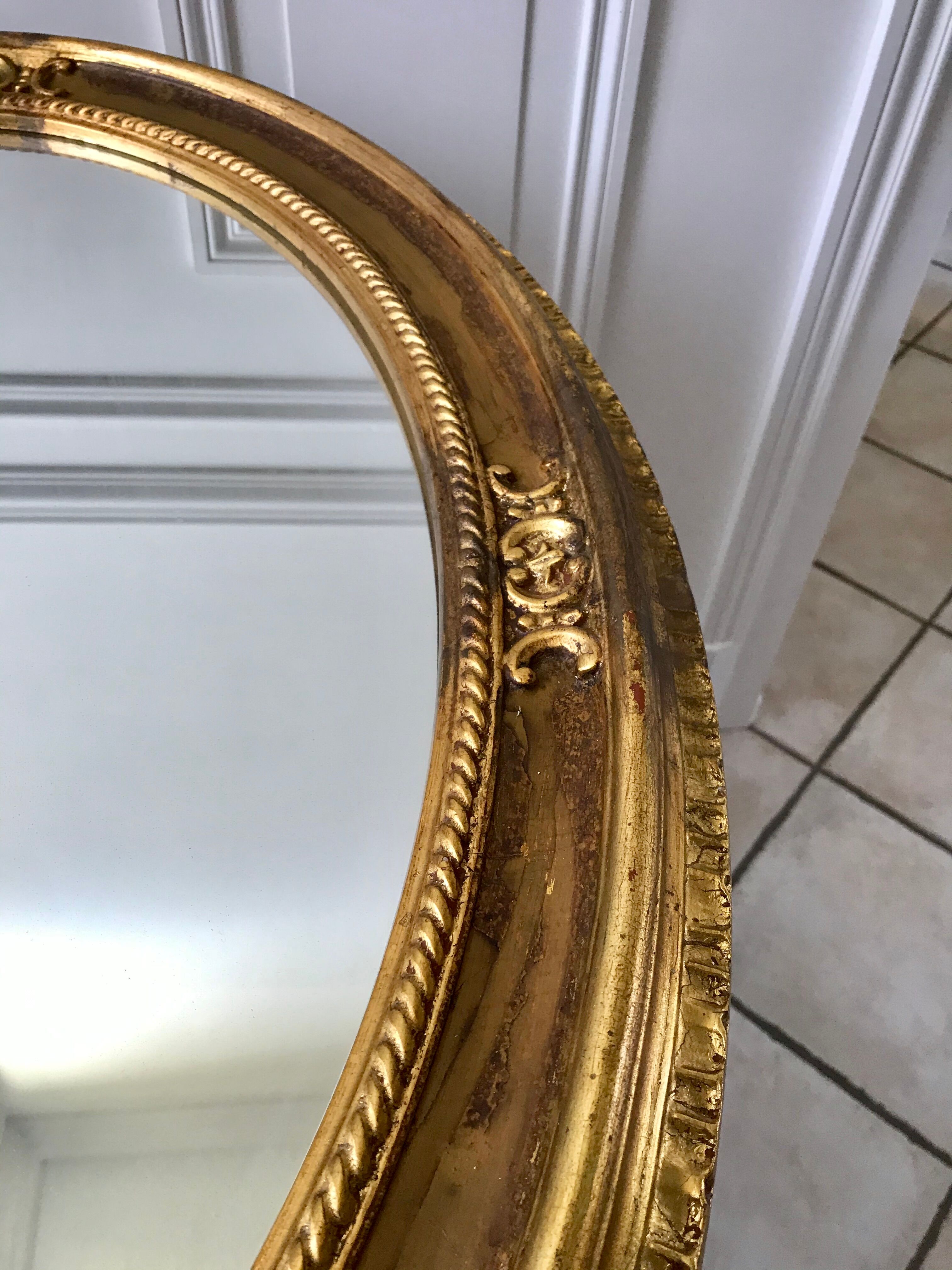 Grand miroir oval en stuc doré vintage