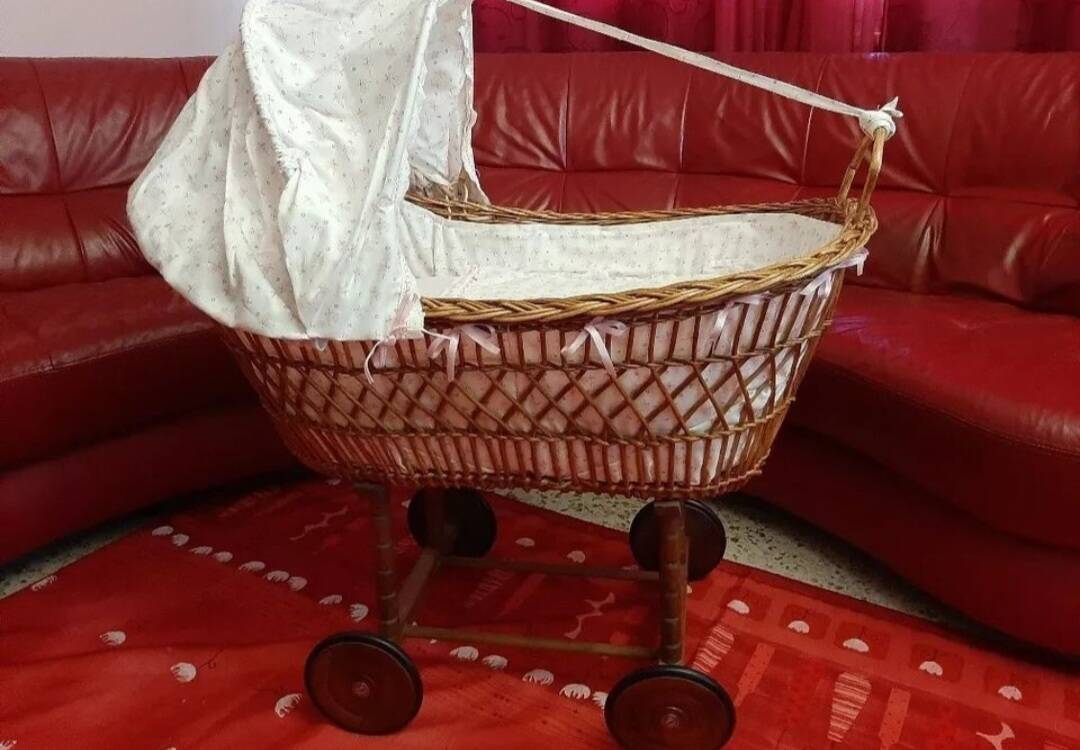 Vintage wicker cradle on wheels from the 1970s.