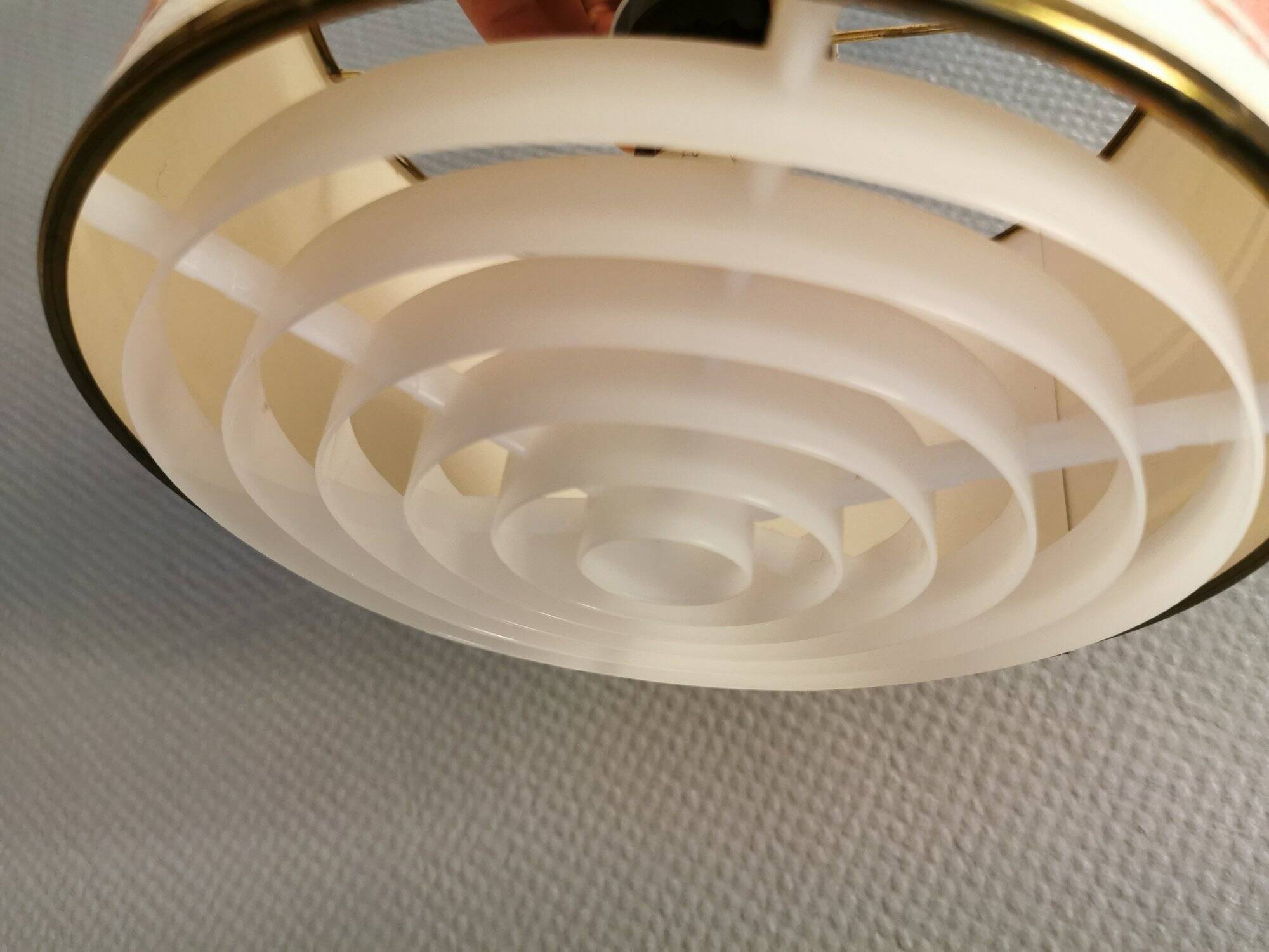 Hanging lamp with brass-coloured details, made of fabric with intact plastic bottom grille.