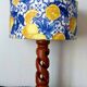 Turned wooden lamp with a lampshade featuring lemon tiles.