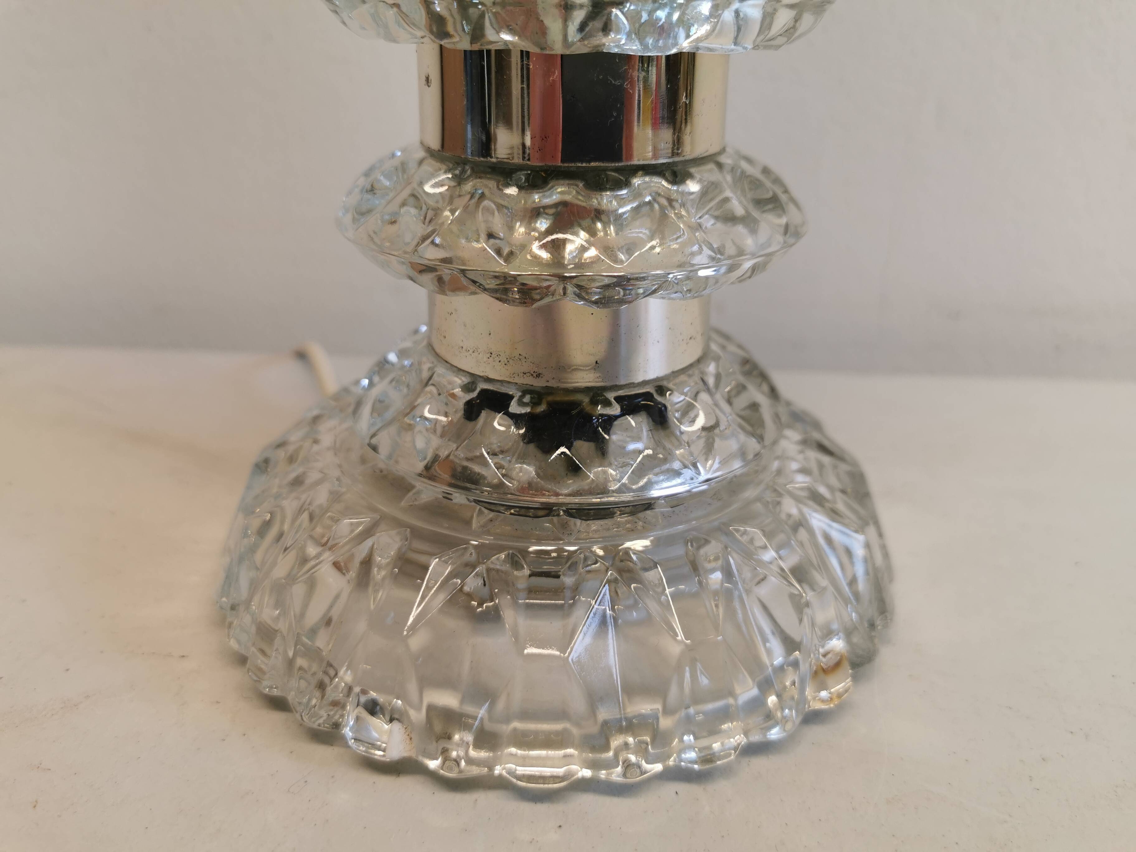 Table lamp made of transparent crystal glass and silver colored spacers.