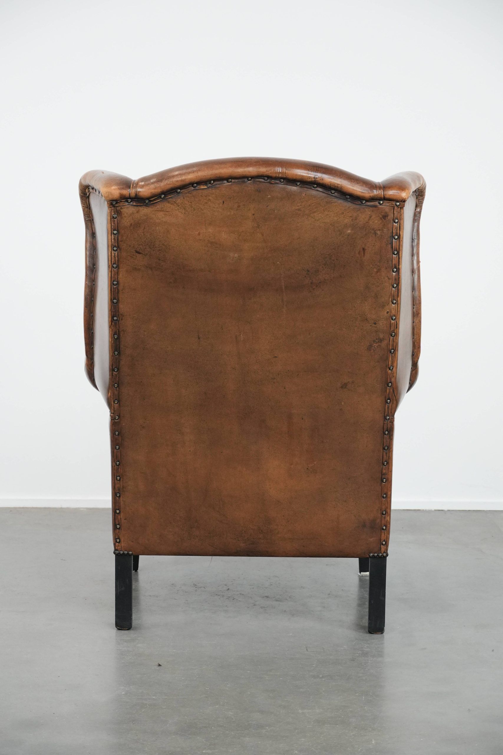 Large and comfortable sheepskin leather wingback chair with black piping