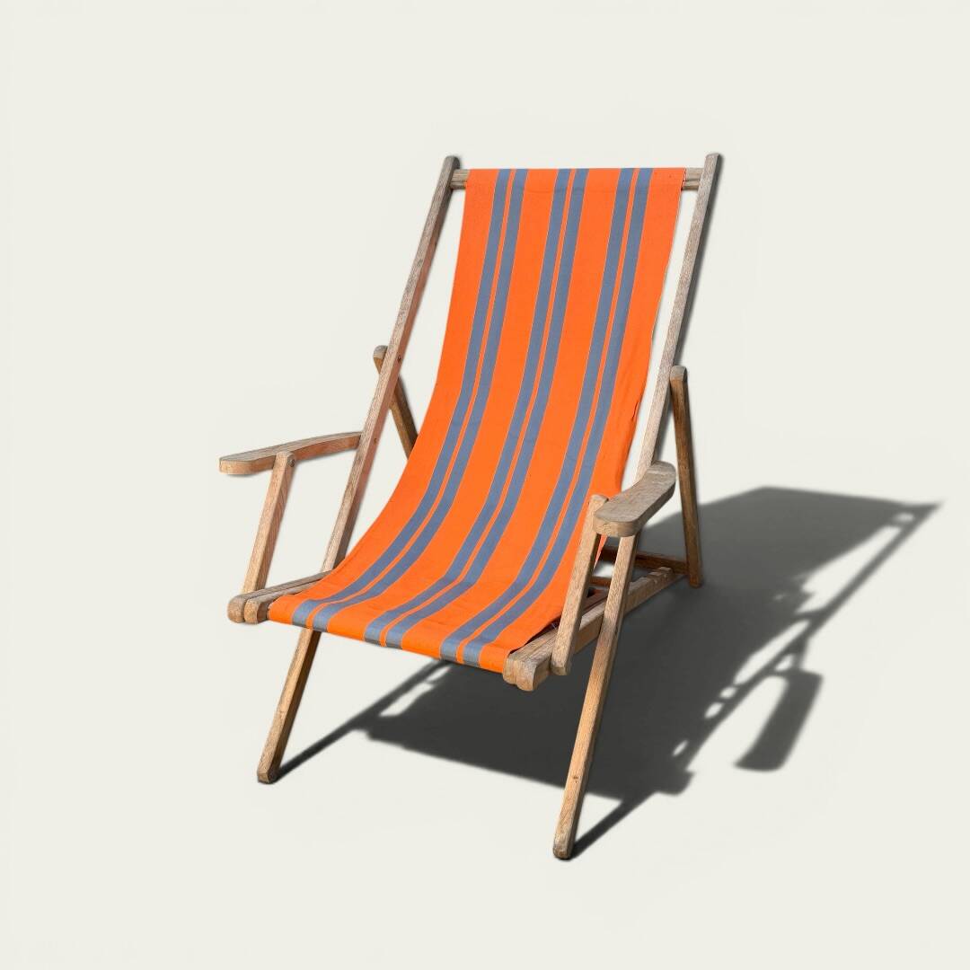 Vintage deck chair with orange and grey striped fabric, original patina.