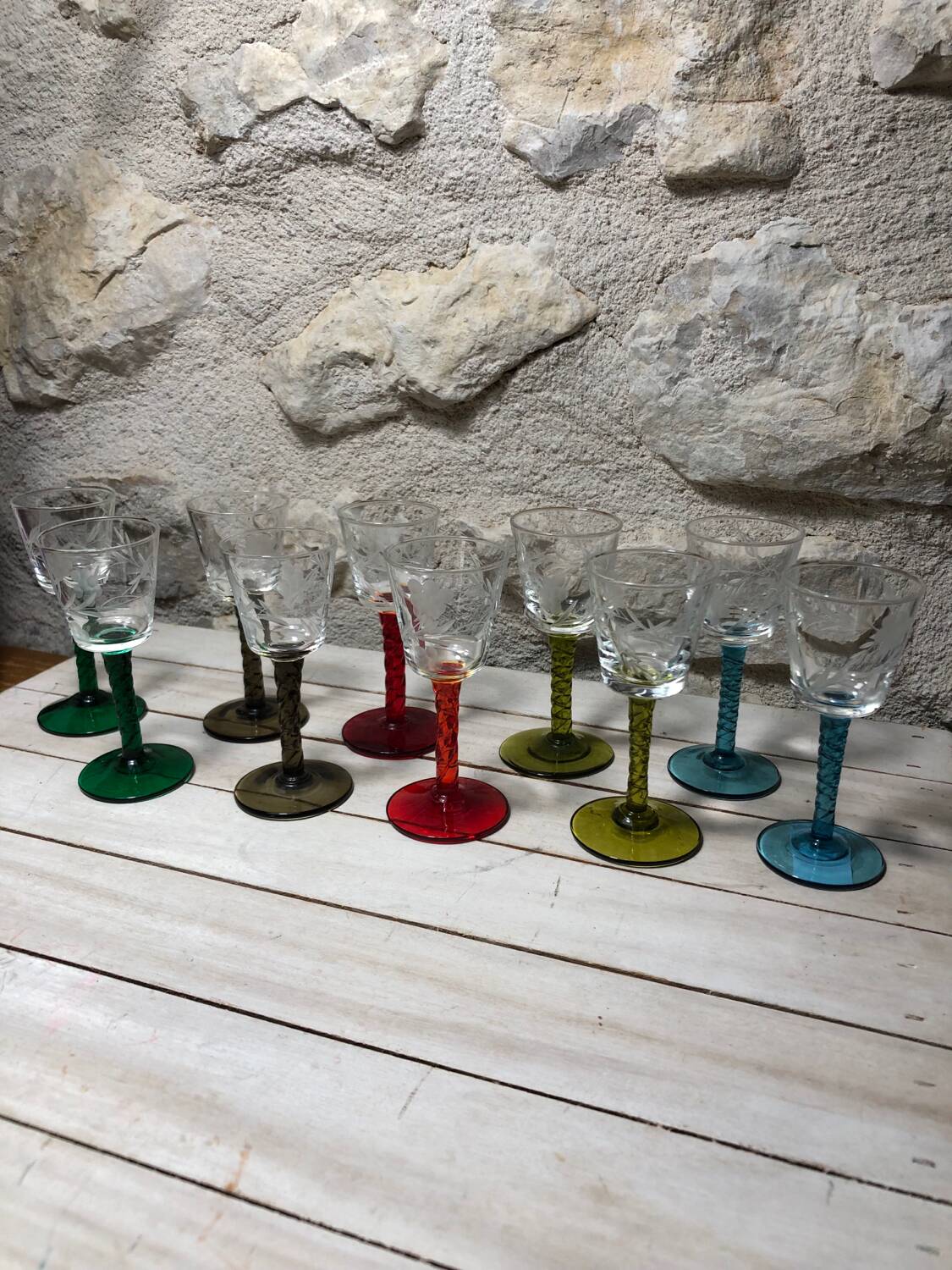 Antique and rare! Sold in a set of 12 colorful twisted stemmed glasses engraved with flowers and leaves