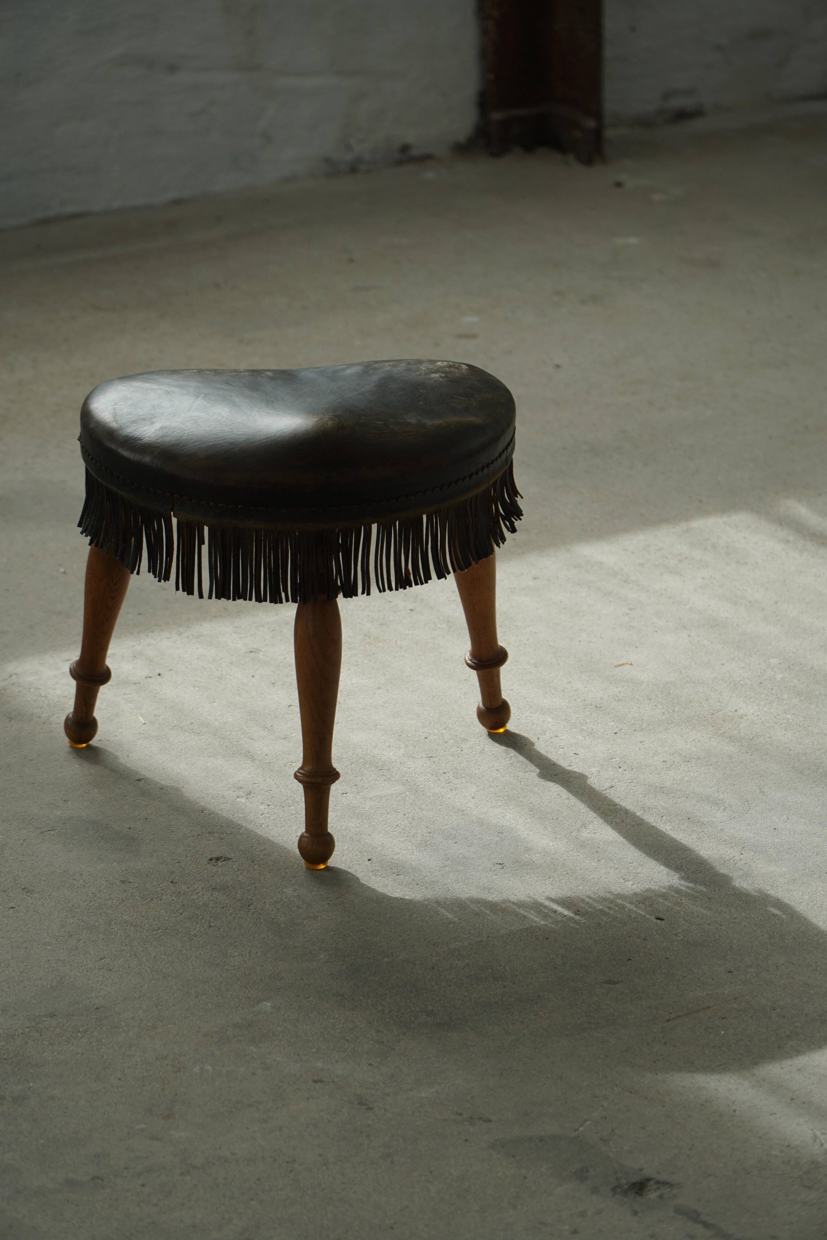 Danish oak tripod stool from the early 20th century with leather fringe, 1930s.