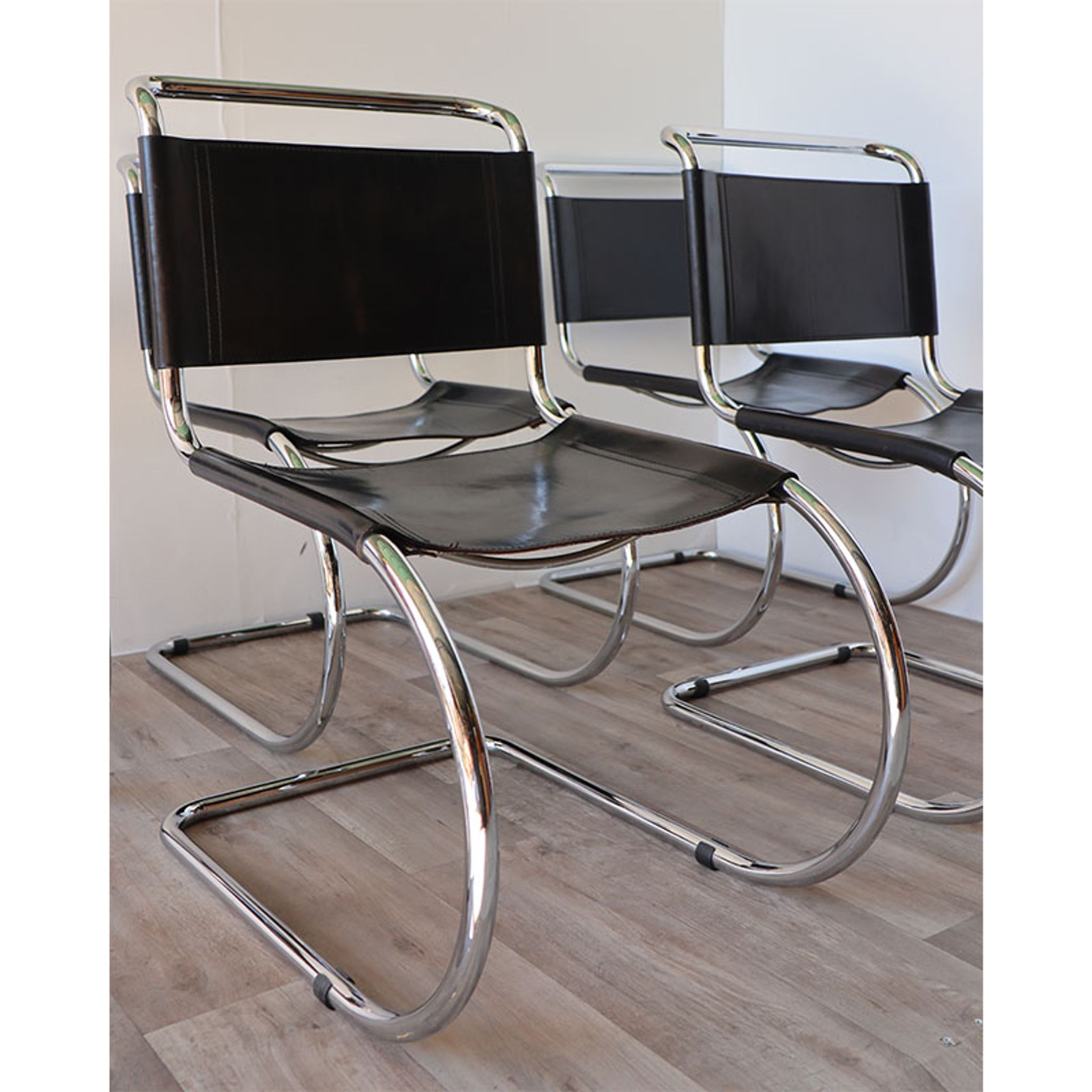 Series of 6 minimalist chairs in chrome metal and black leather around 1970