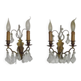 Pair of French antique brass double wall lights with assorted crystals.