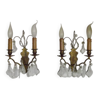 Pair of French antique brass double wall lights with assorted crystals.